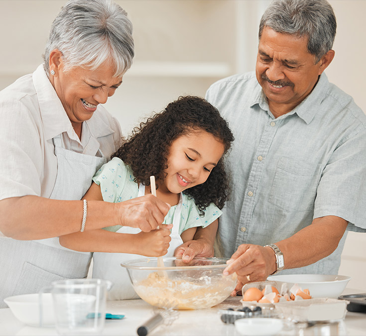 grandparents making breakfast with their granddaughter life insurance in retirement