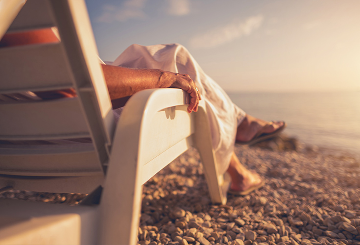 senior woman in beach chair at shoreline types of annuities